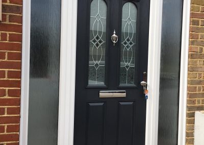 grey door with side panels and top light